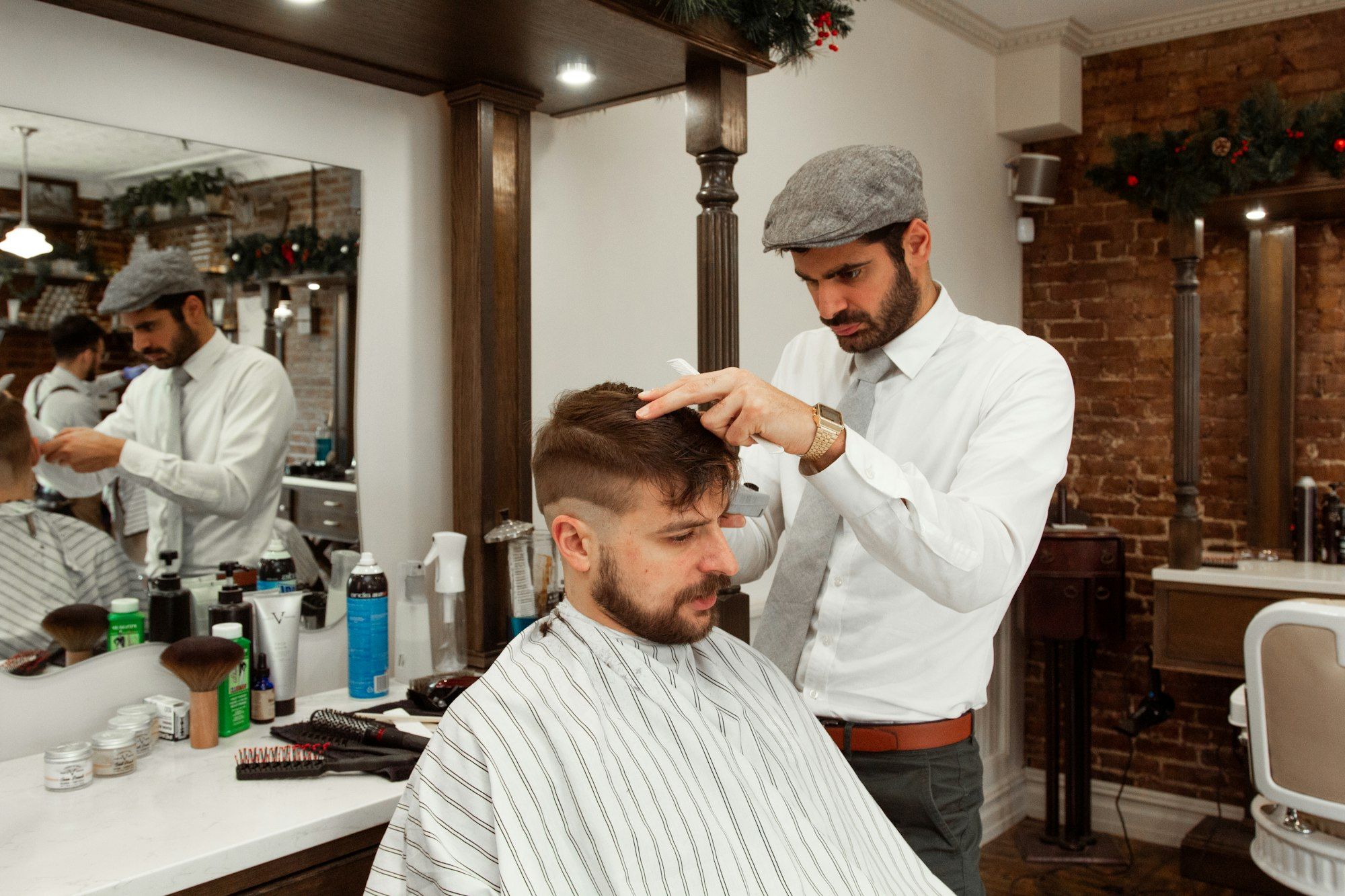 Barbero concentrado cortando el pelo a un cliente en su barbería